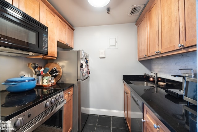 kitchen with a sink, stainless steel appliances, visible vents, backsplash, and baseboards