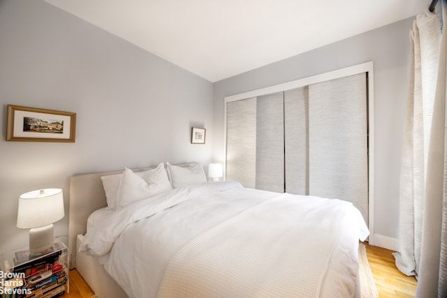 bedroom with light wood finished floors and a closet
