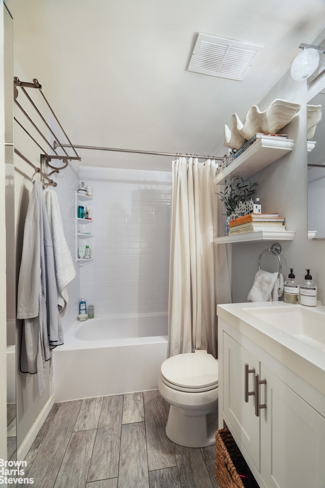 bathroom featuring vanity, toilet, shower / tub combo, visible vents, and wood finished floors