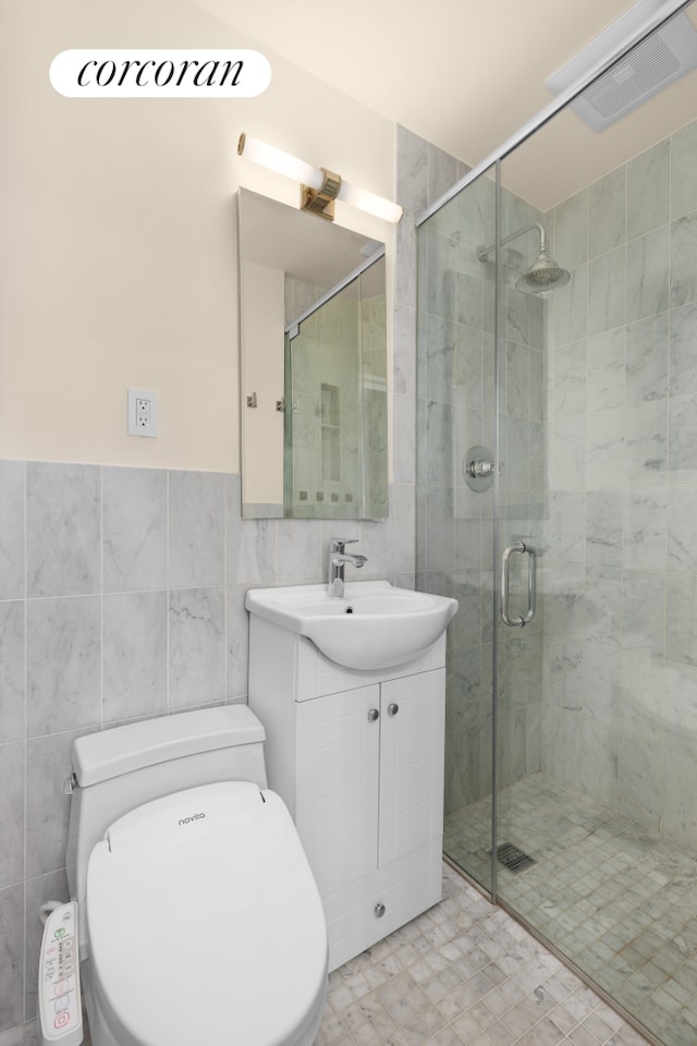 full bath featuring visible vents, tile walls, a shower stall, vanity, and toilet