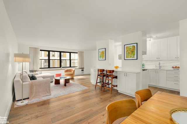 living area with light wood-style flooring and baseboards