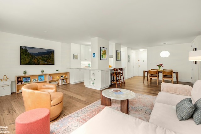living room featuring baseboards and light wood-style flooring