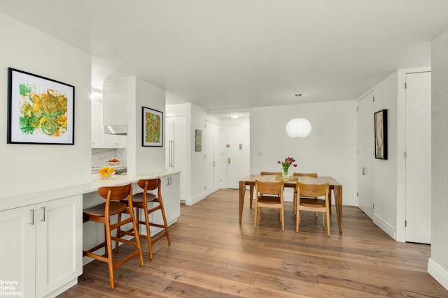 dining space with hardwood / wood-style floors and baseboards
