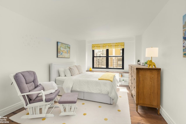 bedroom with baseboards and wood finished floors