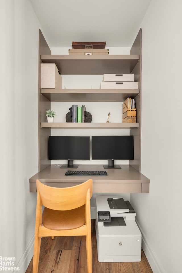 interior space with baseboards, wood finished floors, and built in study area