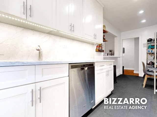 kitchen with tasteful backsplash, dark tile patterned flooring, dishwasher, light countertops, and white cabinets