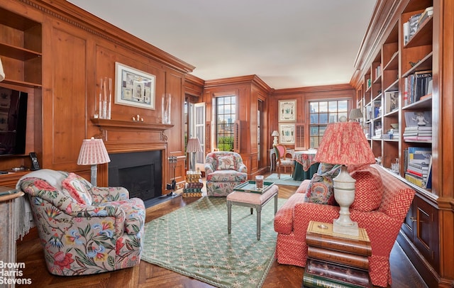 living area featuring ornamental molding and a fireplace with flush hearth