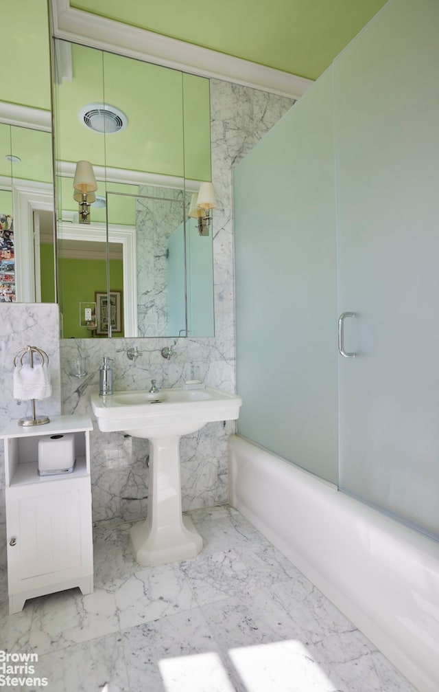 full bathroom featuring marble finish floor, shower / bathing tub combination, visible vents, and tile walls