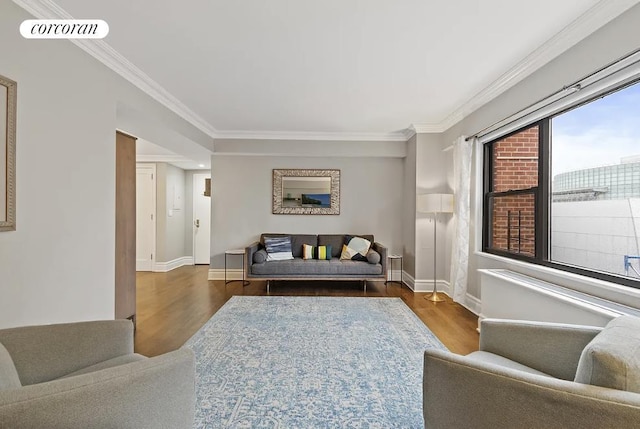 living room with baseboards, ornamental molding, wood finished floors, and visible vents