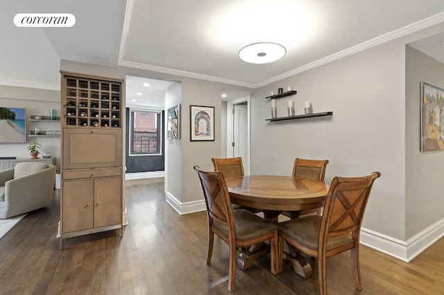 dining space featuring baseboards, ornamental molding, and wood finished floors