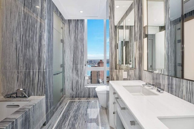 full bathroom featuring a sink, tile walls, toilet, a stall shower, and a garden tub