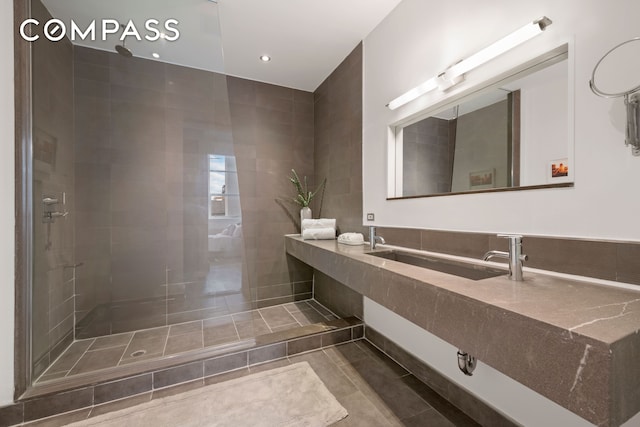 full bath featuring recessed lighting, tile patterned flooring, tiled shower, and vanity