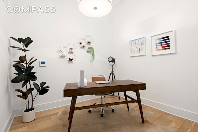 home office with light wood finished floors and baseboards