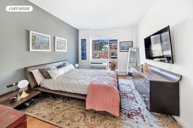 bedroom featuring visible vents, light wood-style flooring, and a wall mounted AC