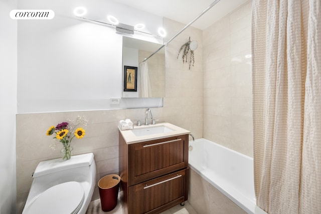bathroom with toilet, shower / bath combo, vanity, and tile walls