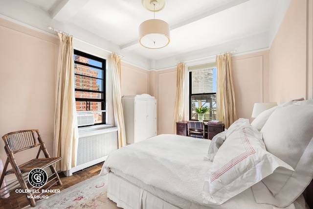 bedroom with radiator, beamed ceiling, and cooling unit