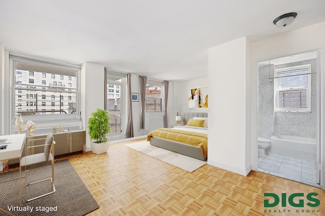 bedroom with baseboards and ensuite bath