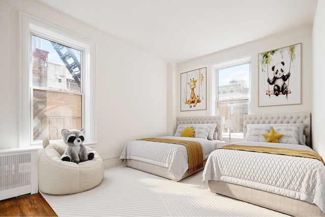 bedroom with radiator heating unit and multiple windows