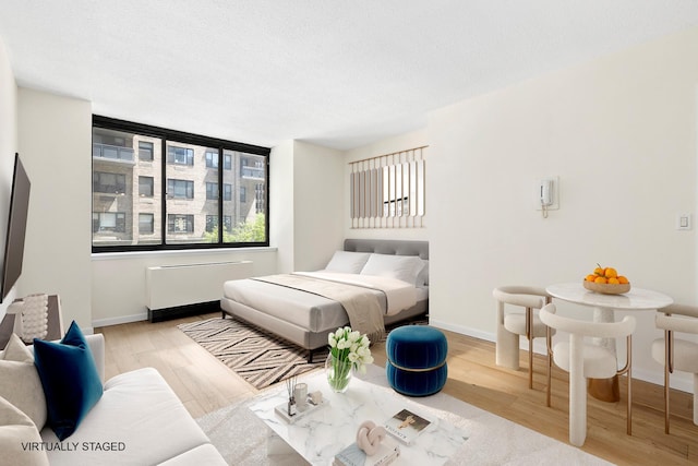 bedroom with baseboards and wood finished floors