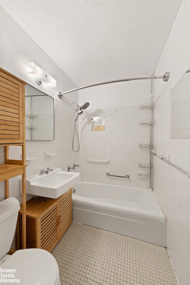 full bath featuring toilet, tile patterned flooring, and tile walls