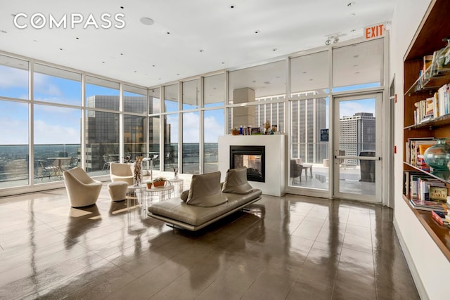 75 Wall St Unit 36F, New York City, NY 10005 - living room with a wall of windows, a glass covered fireplace, plenty of natural light, and a water view