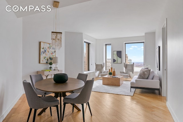 75 Wall St Unit 36F, New York City, NY 10005 - dining room featuring a chandelier and light wood-style floors