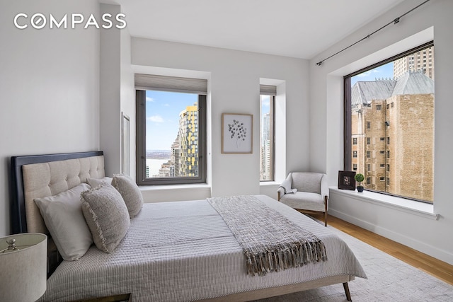 75 Wall St Unit 36F, New York City, NY 10005 - bedroom with multiple windows and wood finished floors