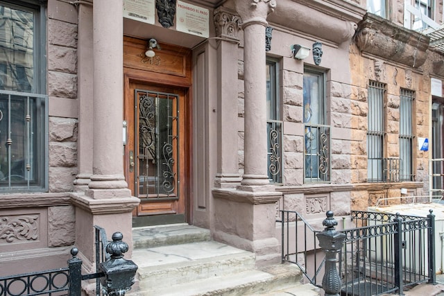 entrance to property featuring covered porch and stone siding