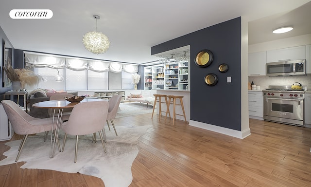 dining room featuring visible vents, light wood finished floors, and a chandelier