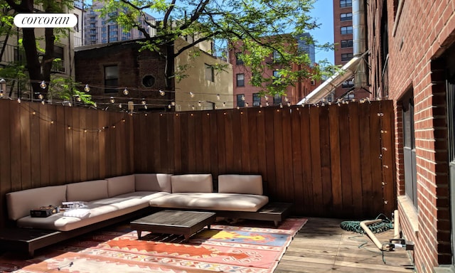 view of patio / terrace with a wooden deck, an outdoor hangout area, and fence