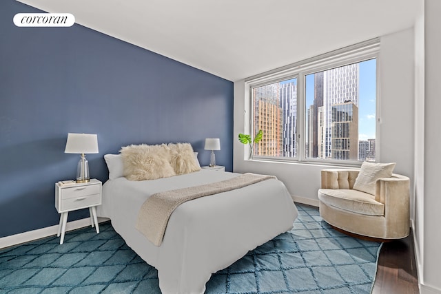 bedroom featuring baseboards, a city view, and vaulted ceiling