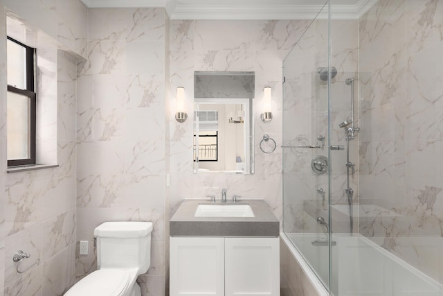 full bath with tile walls, combined bath / shower with glass door, vanity, toilet, and plenty of natural light