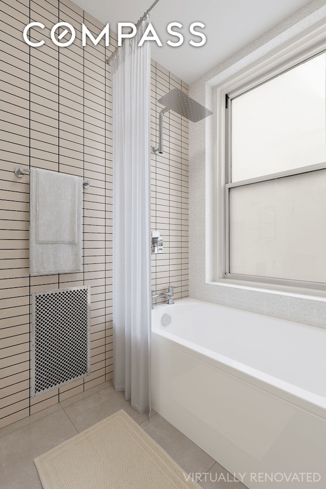 full bathroom featuring tile patterned floors, tile walls, and shower / bathtub combination with curtain