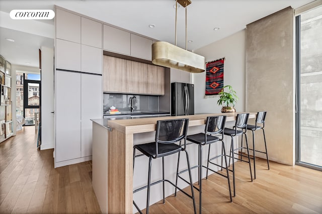 508 Waverly Ave Unit 4, New York City, NY 11238 - kitchen featuring freestanding refrigerator, light wood-style floors, a breakfast bar, modern cabinets, and recessed lighting