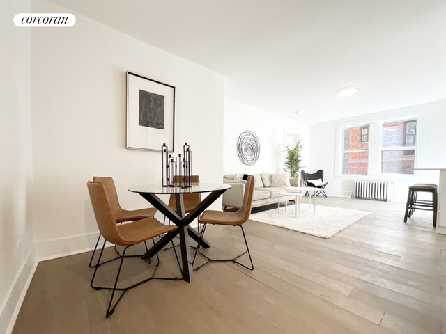 148-09 Northern Blvd Unit 1J, New York City, NY 11354 - dining room with radiator, baseboards, and wood finished floors