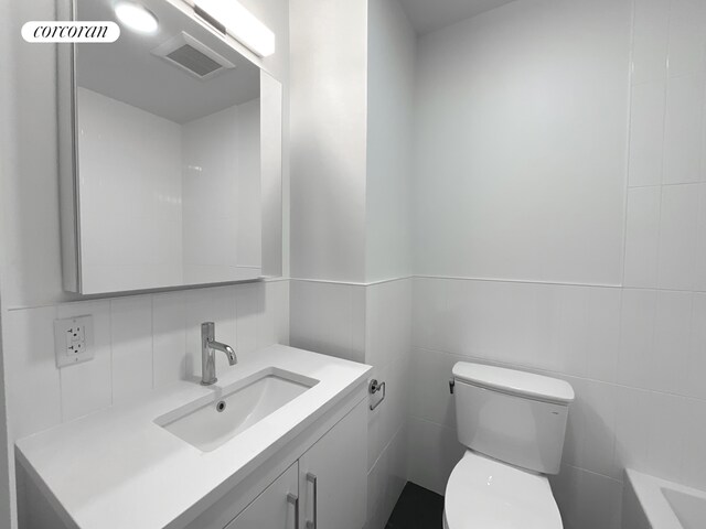 148-09 Northern Blvd Unit 1J, New York City, NY 11354 - bathroom with toilet, tile walls, vanity, decorative backsplash, and a bathtub