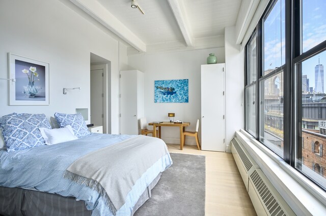 30 Main St Unit 7H, New York City, NY 11201 - bedroom with beam ceiling, multiple windows, and light wood-style flooring