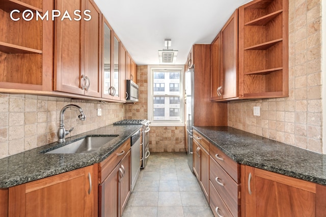 kitchen featuring open shelves, a sink, appliances with stainless steel finishes, brown cabinetry, and backsplash