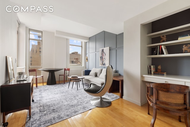 sitting room with baseboards and light wood-style flooring