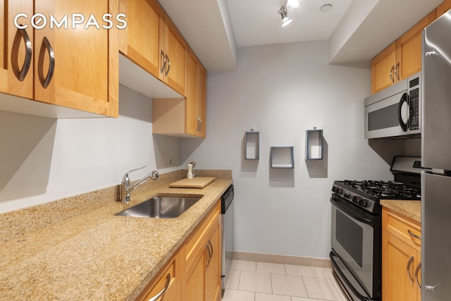 250 E 30th St Unit 14B, New York City, NY 10016 - kitchen with appliances with stainless steel finishes, a sink, light tile patterned floors, light stone countertops, and baseboards