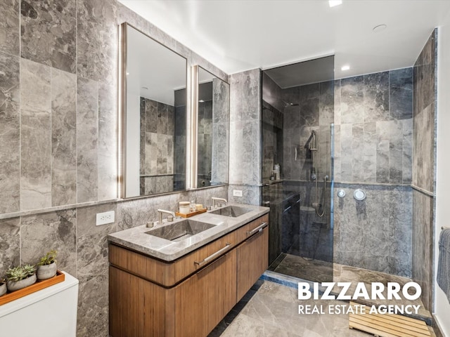 208 Delancey St Unit 8F, New York City, NY 10002 - bathroom featuring tile walls, marble tiled flooring, a walk in shower, toilet, and double vanity