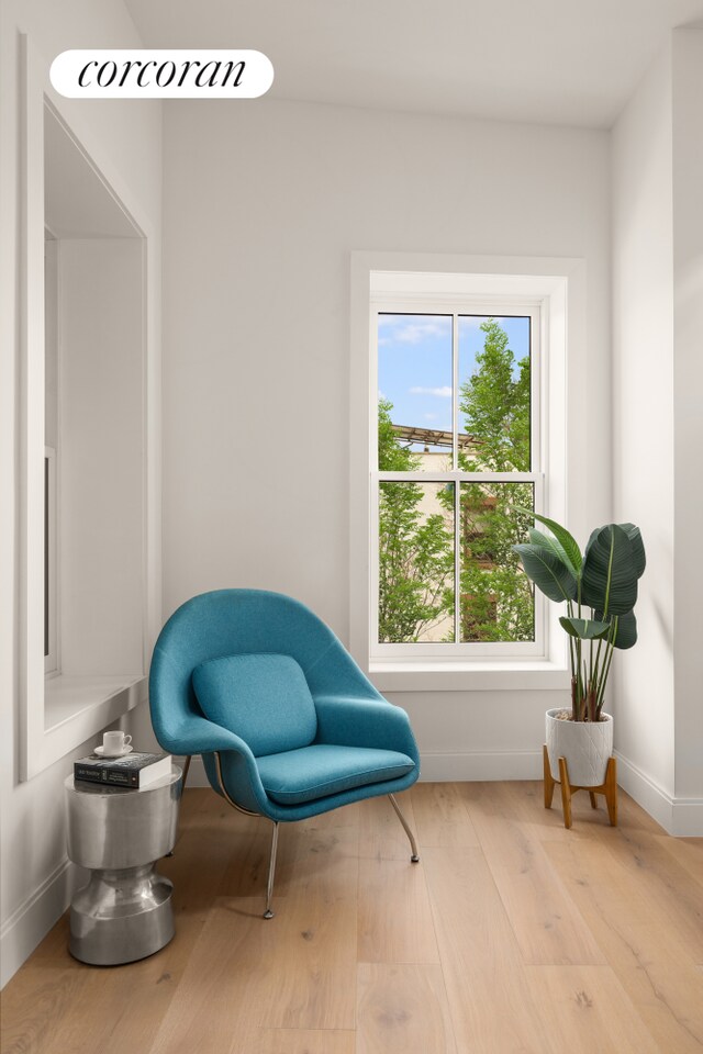 sitting room with baseboards and wood finished floors