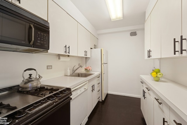 kitchen featuring light countertops, white cabinetry, black appliances, visible vents, and a sink