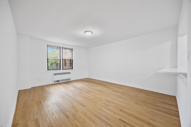 302 96th St Unit 2-W, New York City, NY 11209 - spare room featuring radiator, light wood-style floors, and baseboards