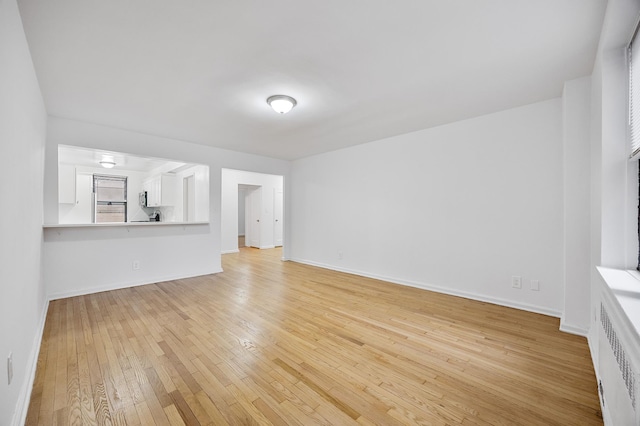 302 96th St Unit 2-W, New York City, NY 11209 - unfurnished living room featuring light wood finished floors and radiator heating unit