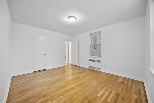 302 96th St Unit 2-W, New York City, NY 11209 - unfurnished room with radiator and light wood-style flooring
