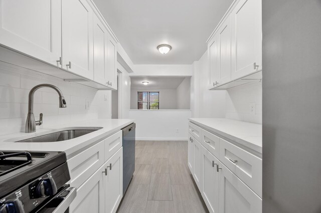 302 96th St Unit 2-W, New York City, NY 11209 - kitchen featuring backsplash, stainless steel appliances, white cabinetry, light stone counters, and light wood-style flooring