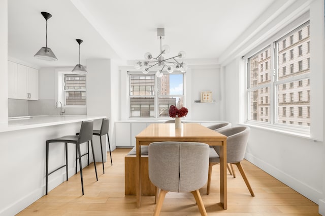69 5th Ave Unit 9Gh, New York City, NY 10003 - dining room with light wood-type flooring, a chandelier, and baseboards