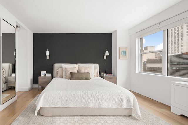 69 5th Ave Unit 9Gh, New York City, NY 10003 - bedroom with light wood-style floors, baseboards, and an accent wall