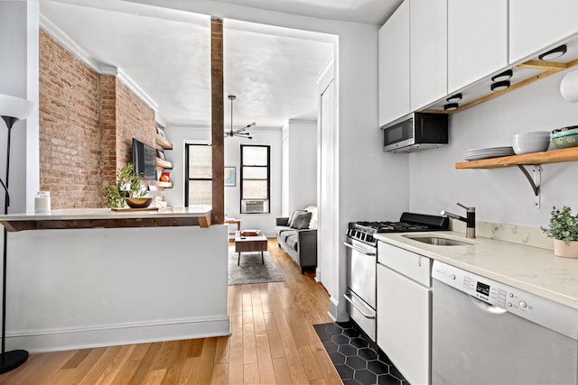 kitchen with white cabinets, open shelves, a sink, light wood-type flooring, and stainless steel appliances